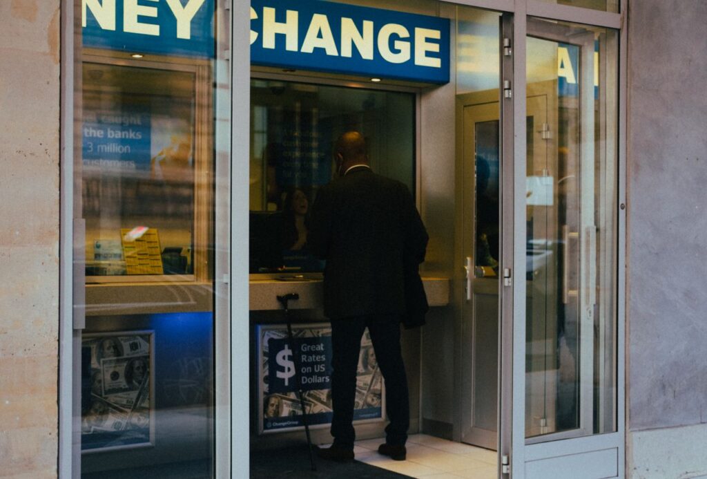 Home A businessman changes money at a currency exchange counter indoors.
