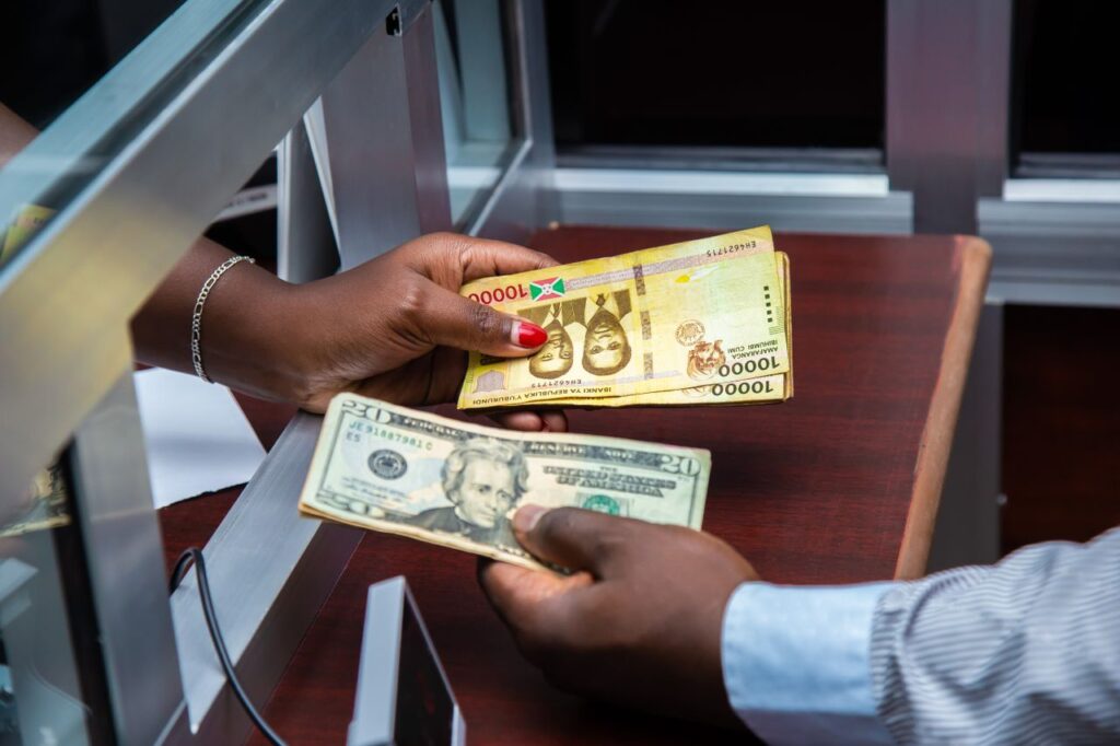 Home Burundian franc and US dollar exchange transaction at bank counter.